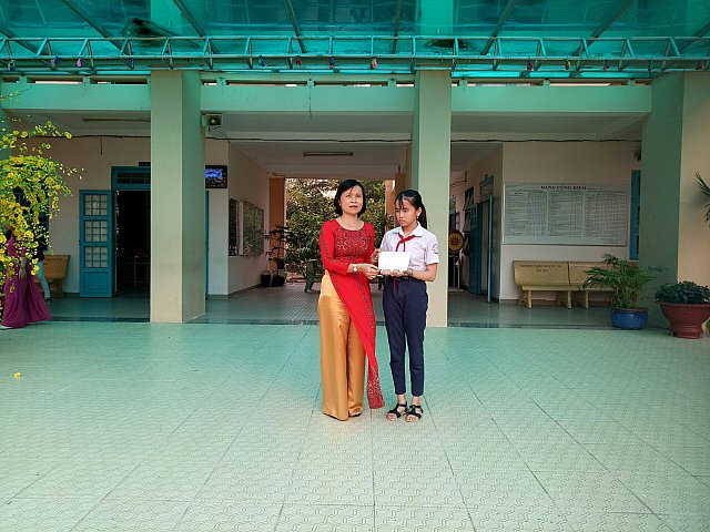 Cô Diệp Thị Ngọc Dung trao học bổng cho em Hùynh Thị Thúy Vy lớp 7A1