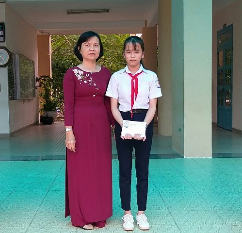 Cô Diệp Thị Ngọc Dung - Hiệu trưởng trao học bổng cho em Huỳnh Thị Thúy Vy lớp 8a1