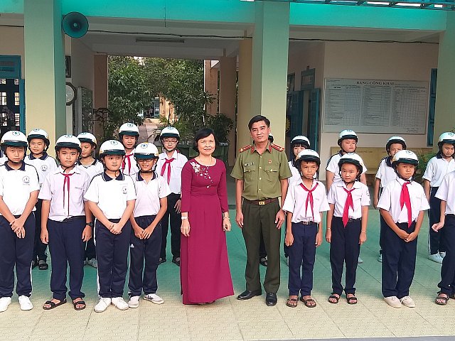 Thượng úy Võ Thành Nghĩa - Công an Tỉnh và Cô Diệp Thị Ngọc Dung - Bí thư chi bộ tặng nón bảo hiểm cho học sinh